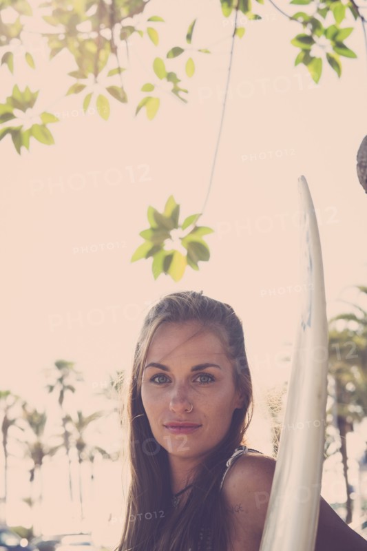 Portrait of Caucasian woman holding surfboard