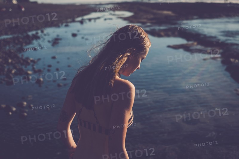 Caucasian woman looking down on beach