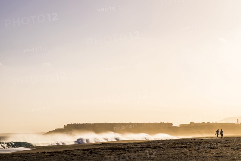 Distant people walking on beach