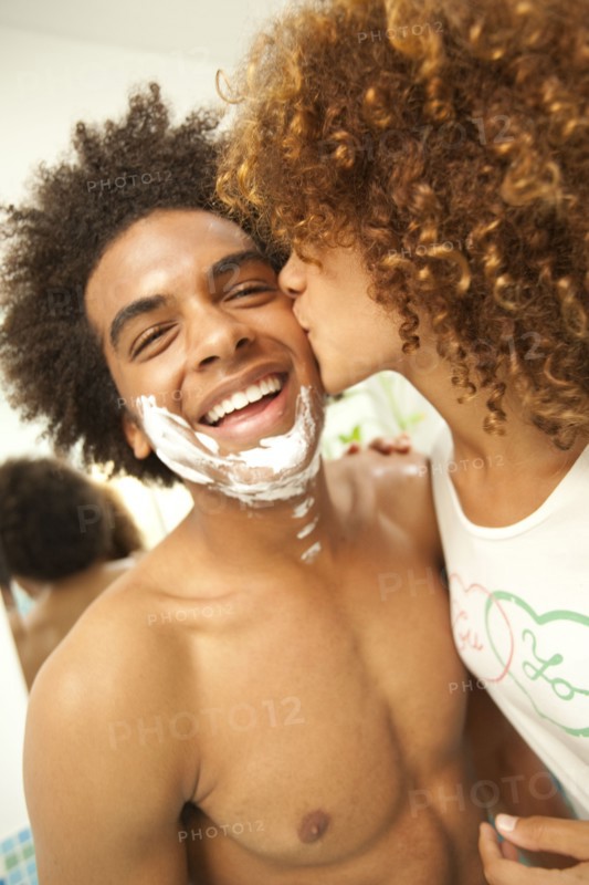 Girlfriend kissing boyfriend's shaving cream-covered face