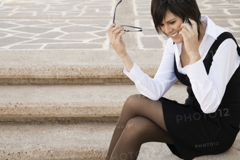 Hispanic businesswoman talking on cell phone outdoors