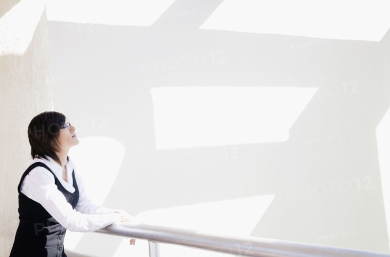 Hispanic businesswoman standing in office lobby