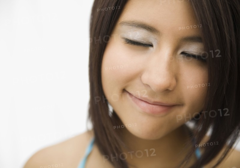 Hispanic teenage girl smiling with eyes closed