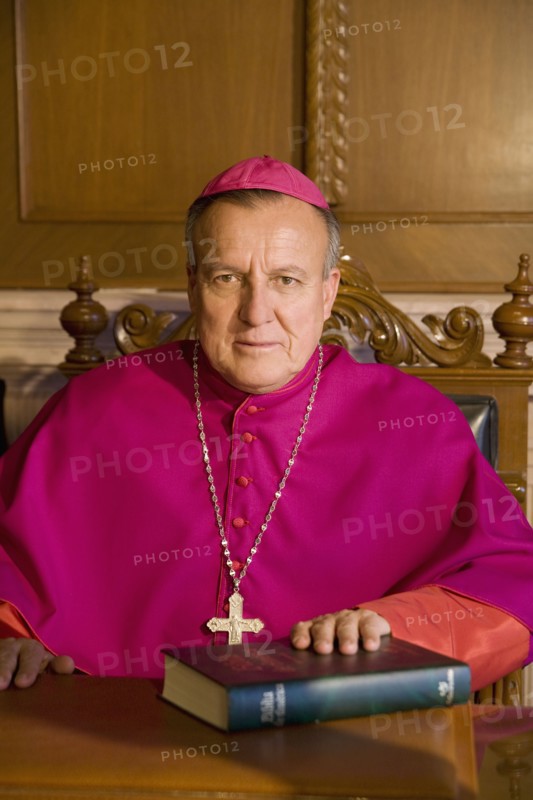 Hispanic bishop sitting with bible