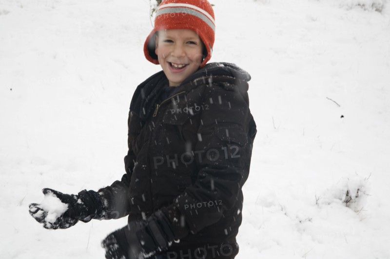 Hispanic boy throwing snowballs