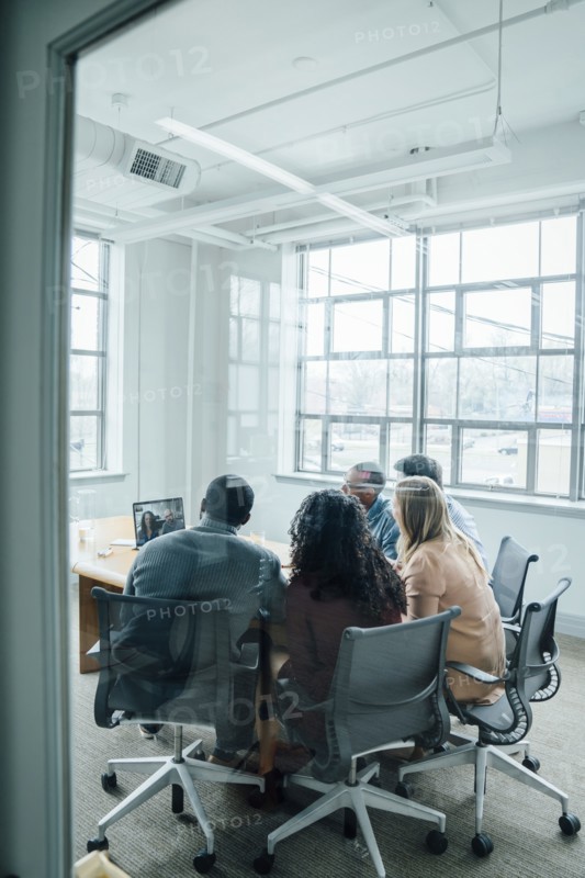 Business people on video conference behind window