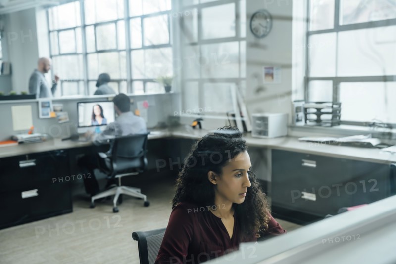 Business people working in office behind window