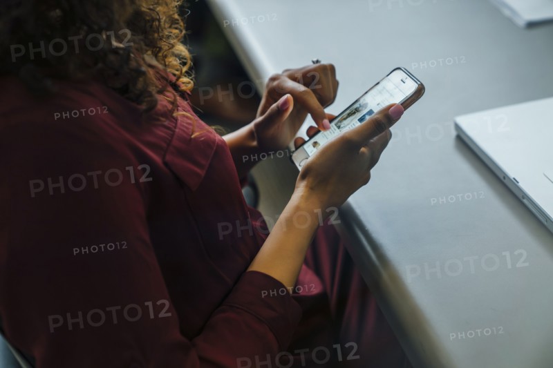 Mixed race businesswoman using cell phone