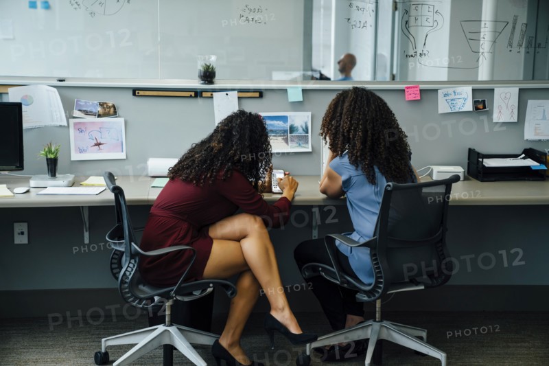 Businesswomen using cell phone in office