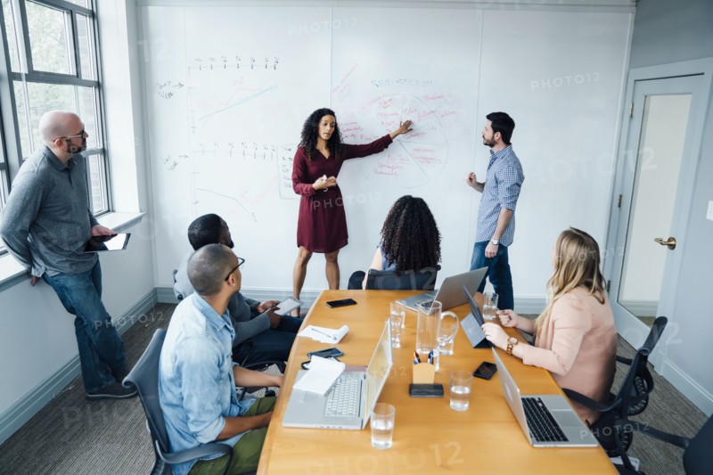 Business people using whiteboard in meeting