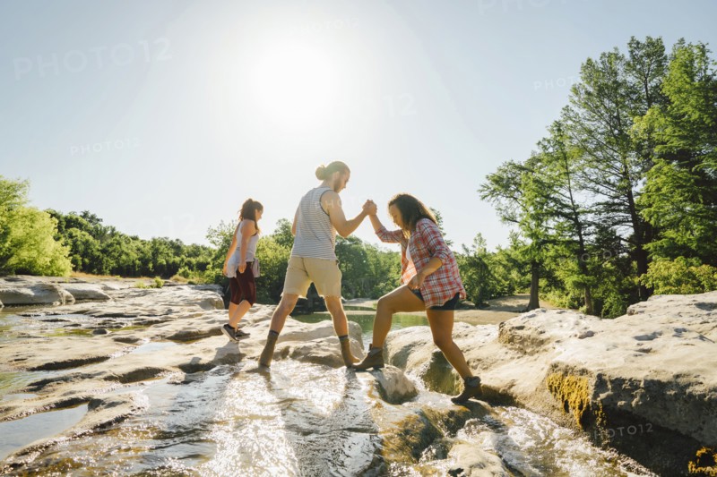 Man helping woman crossing river