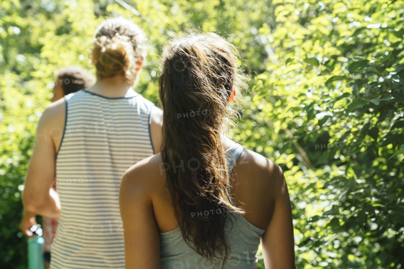 Rear view of friends walking near trees