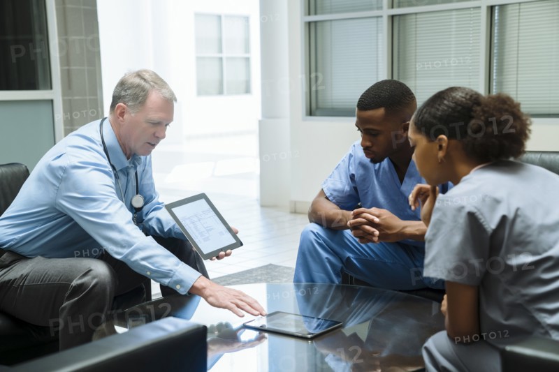 Doctor and nurses discussing digital tablet
