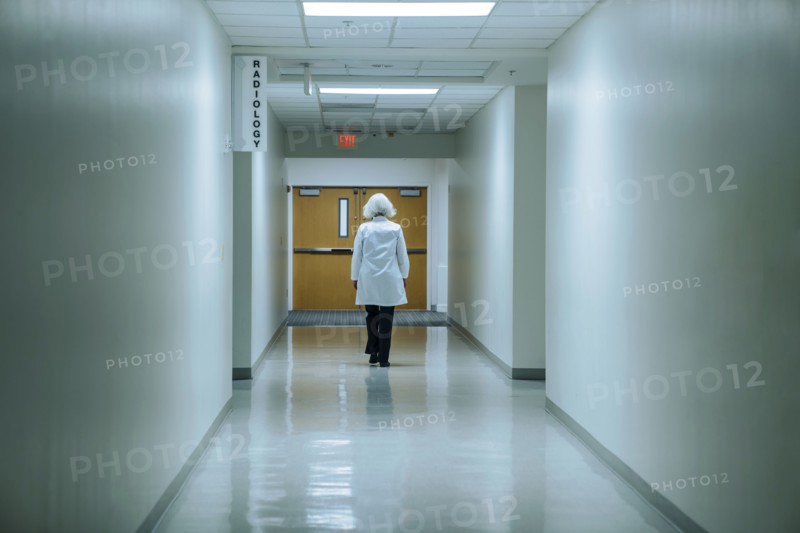 Caucasian doctor walking in hospital