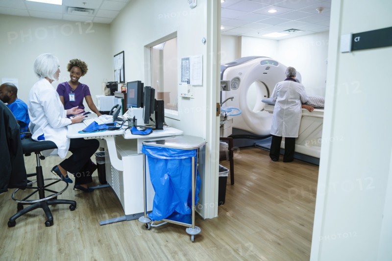 Doctor and technician talking near scanner