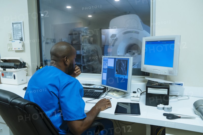 Black nurse using computer near scanner