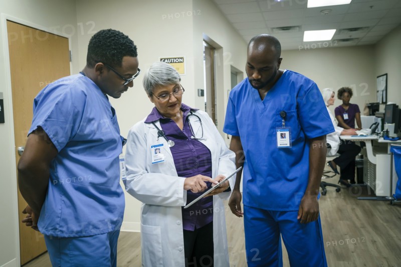 Doctor and nurses discussing digital tablet