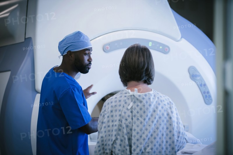 Technician talking to patient at scanner