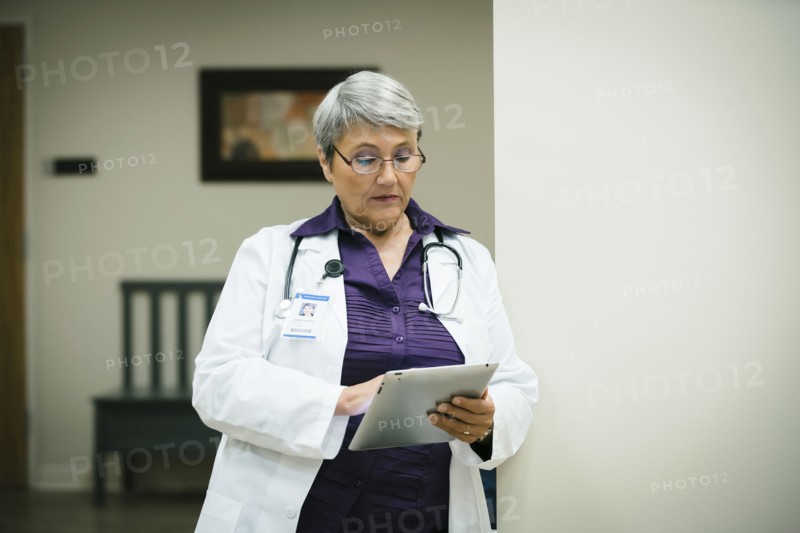Mixed race doctor using digital tablet