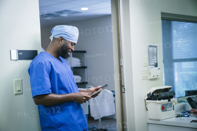 Smiling black nurse using digital tablet