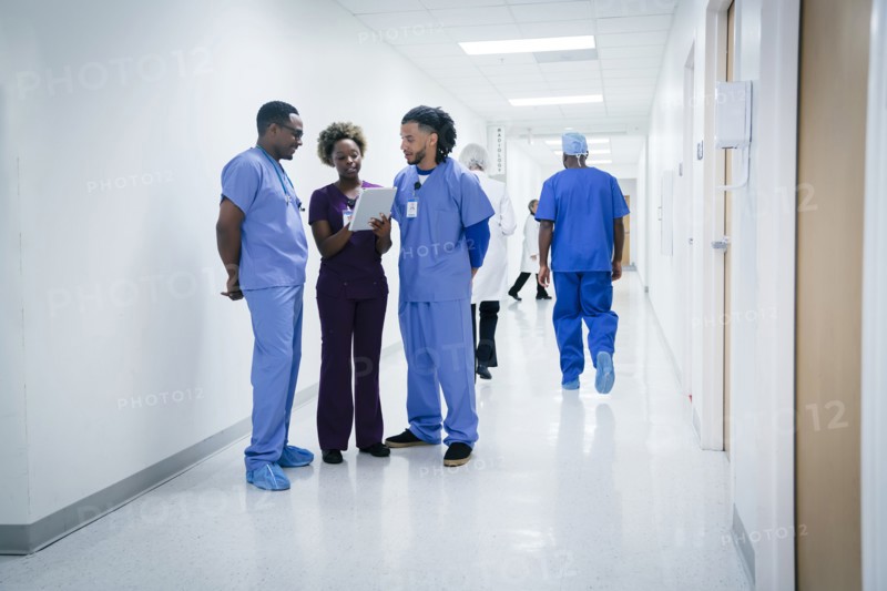 Nurses discussing digital tablet in hospital