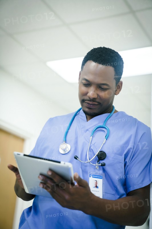 Black nurse using digital tablet in hospital