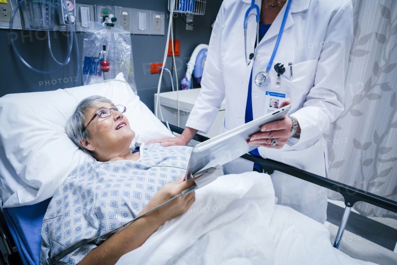 Doctor showing digital tablet to patient
