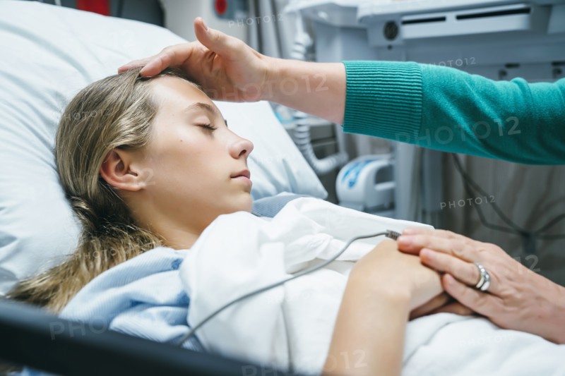 Caucasian doctor comforting patient in hospital bed