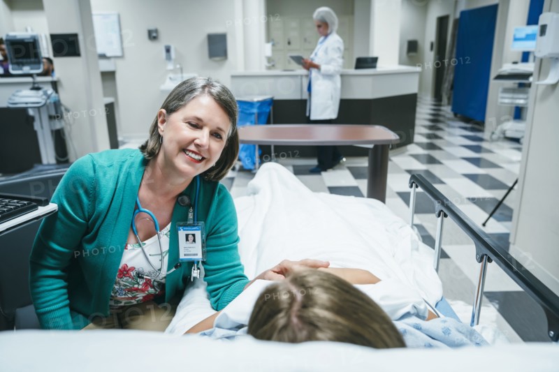 Caucasian doctor comforting patient in hospital bed