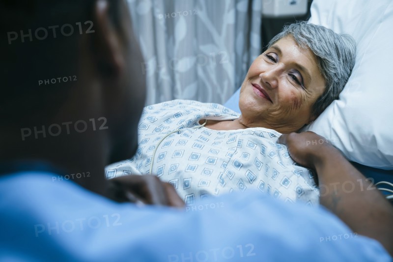 Nurse talking to patient in hospital bed