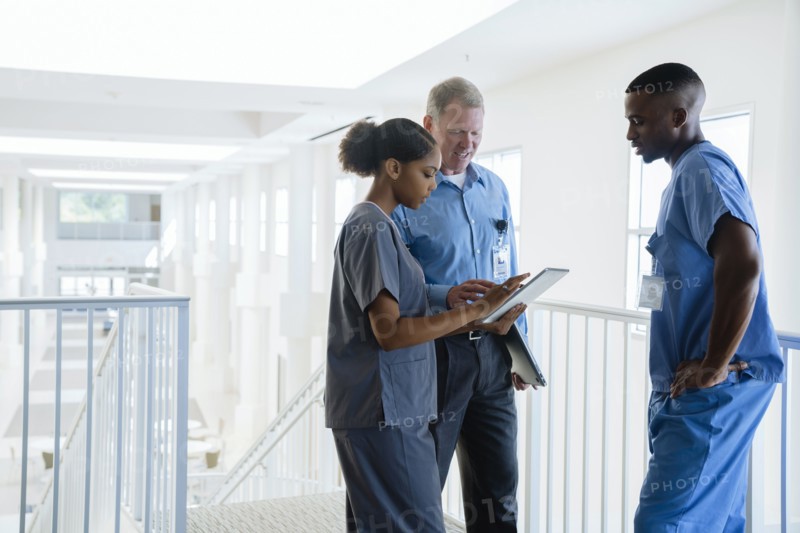 Doctor and nurses using digital tablet near staircase