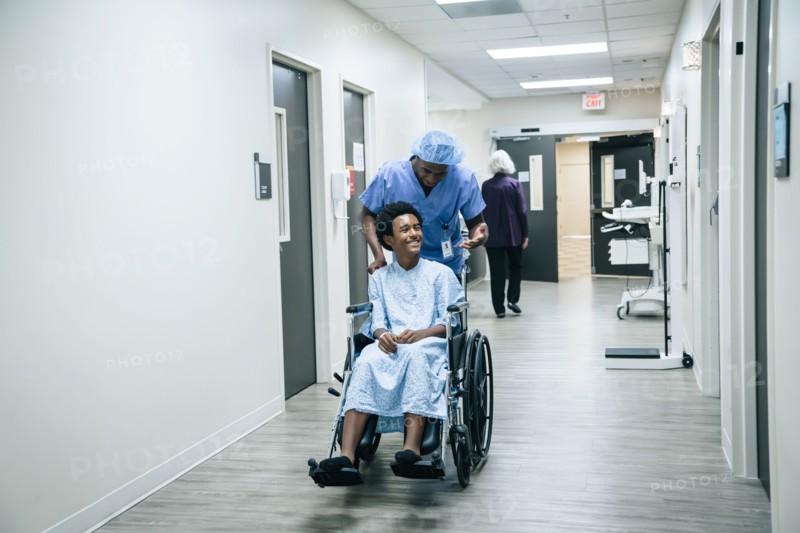 Nurse pushing boy in wheelchair