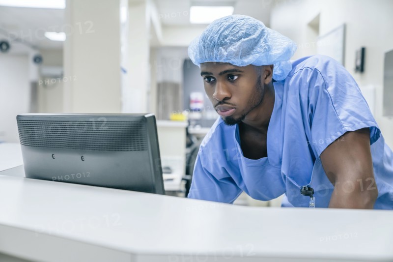 Black doctor using computer in hospital