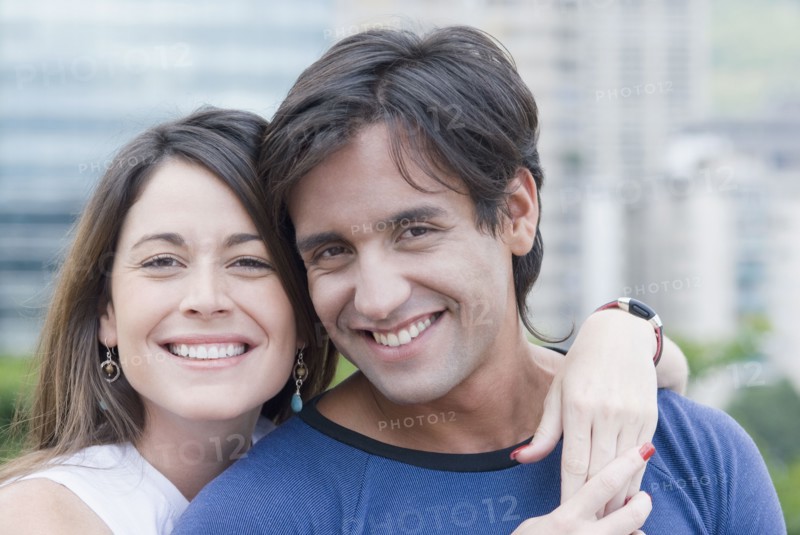Hispanic couple hugging outdoors