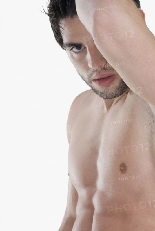 Bare-chested Hispanic man holding arm up