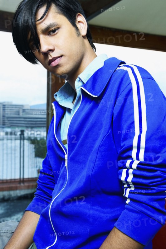 Low angle view of young Hispanic man in urban scene