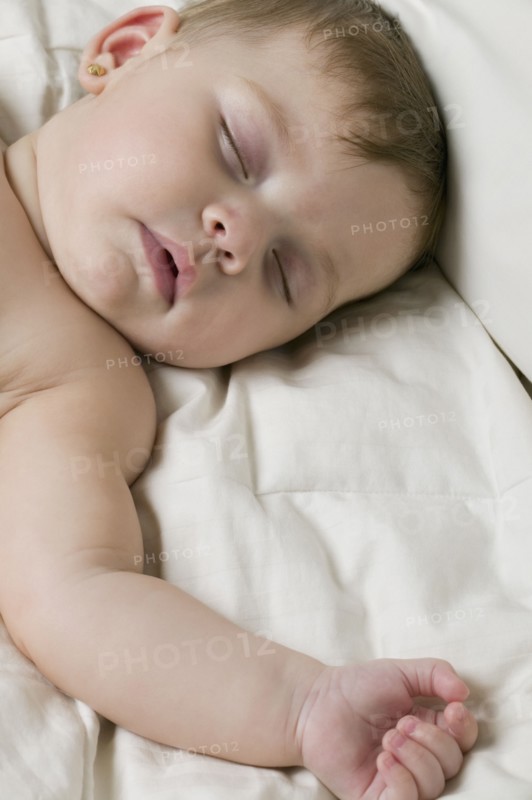 Hispanic baby sleeping on bed
