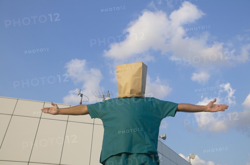 Hispanic male doctor wearing bag over head