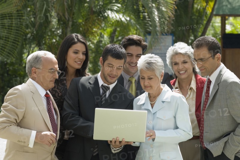 Group of Hispanic businesspeople looking at laptop