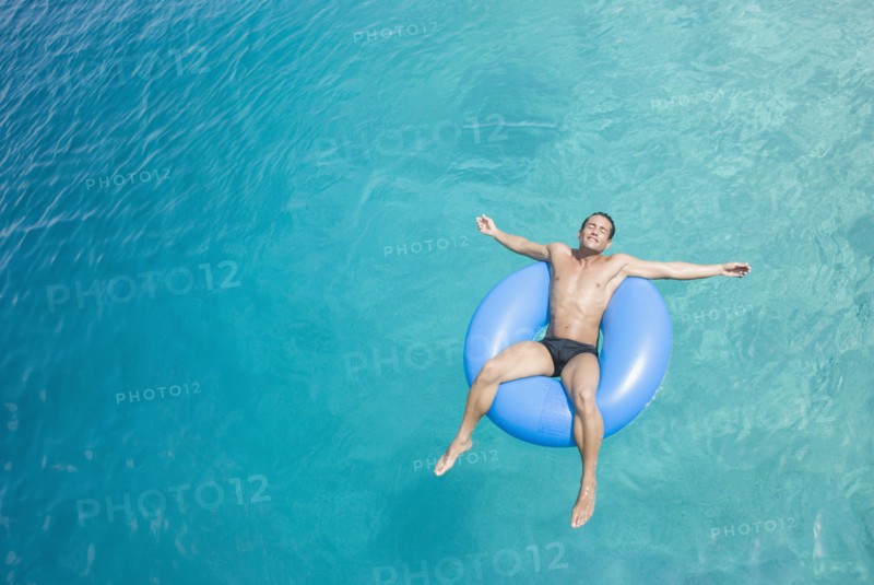 Hispanic man on float in water