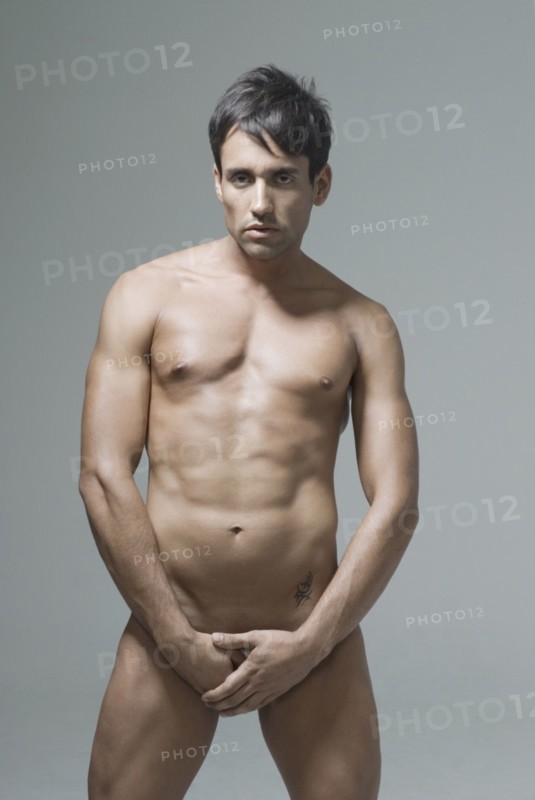 Nude Hispanic man covering his groin
