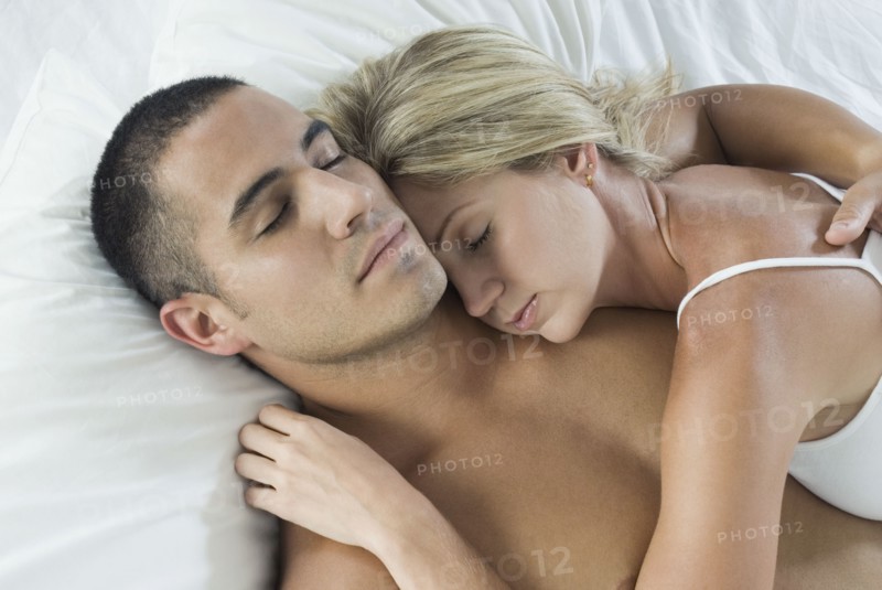 Hispanic couple sleeping in bed