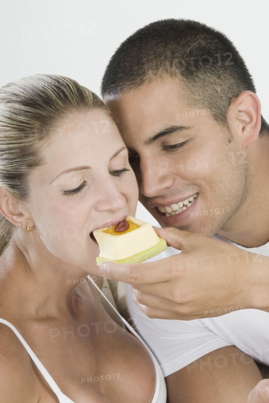 Hispanic man feeding girlfriend dessert
