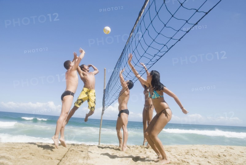 Multi-ethnic friends playing volleyball at beach