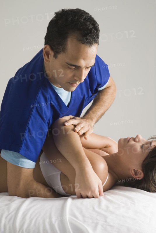 Chiropractor adjusting woman's back