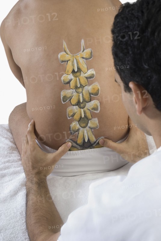 Chiropractor adjusting man's back