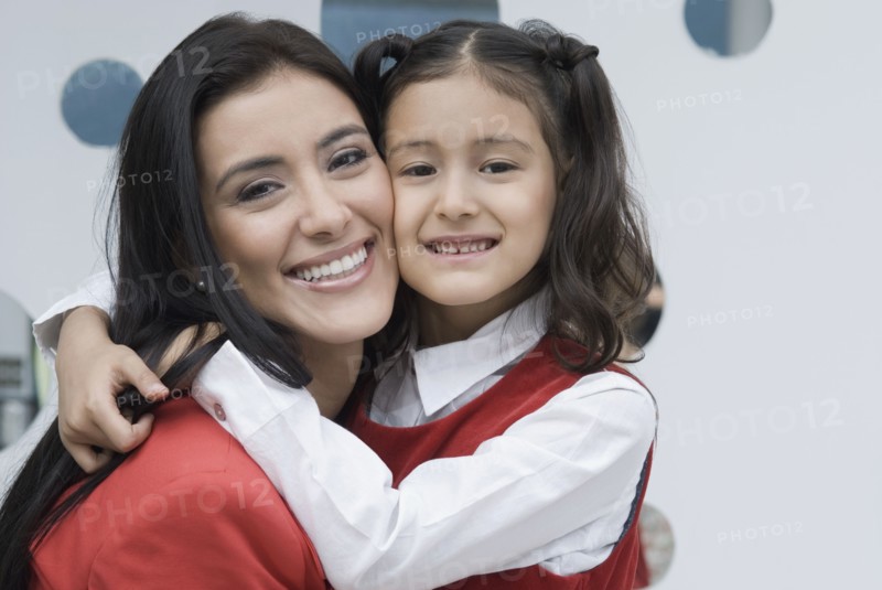 Hispanic mother hugging daughter