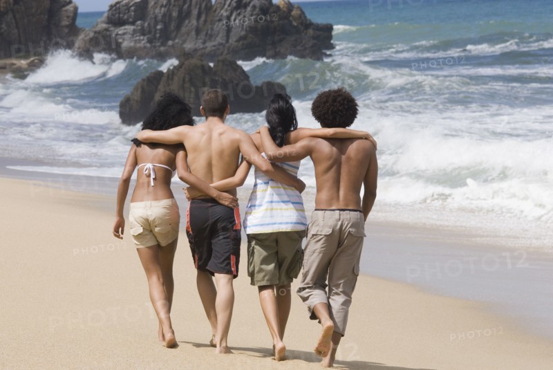Multi-ethnic friends walking on beach