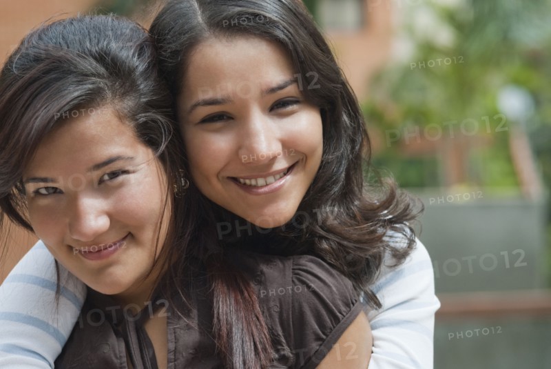 Hispanic sisters hugging