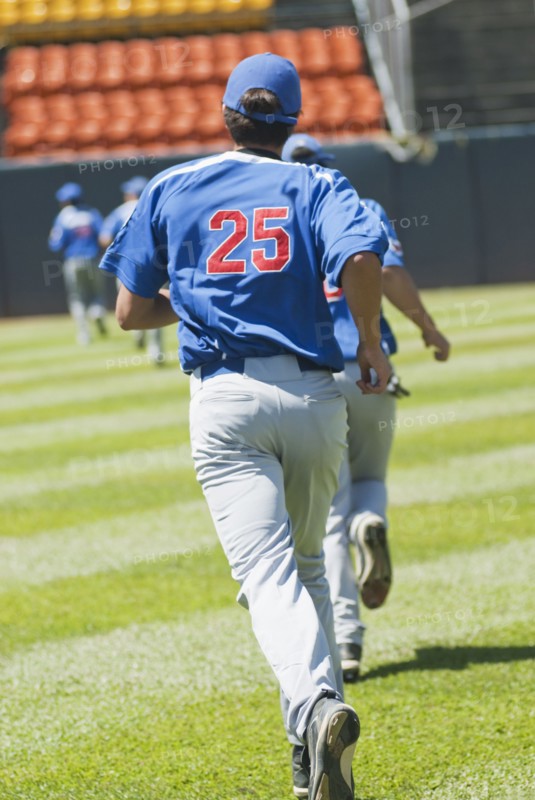 Hispanic baseball player running on field